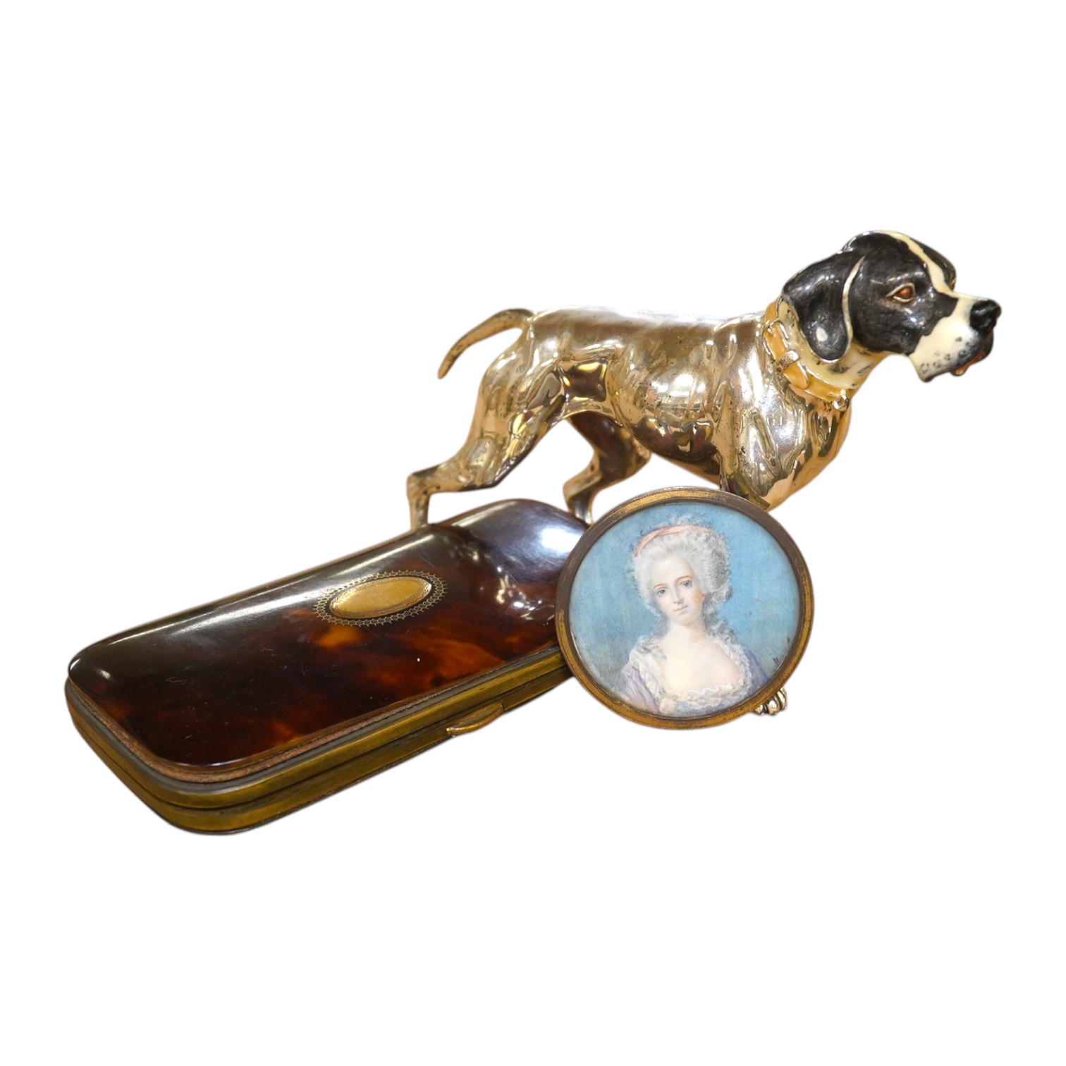 An enamelled silver plated model of a hound, tortoiseshell cigar case and watercolour miniature of a lady, largest 14cm wide. Condition - fair to good